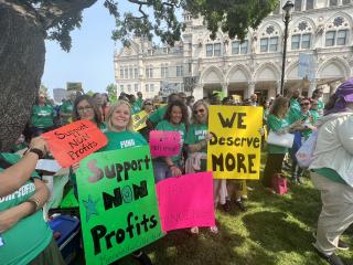 A crowd of people with signs and shirts reading, "Support Nonprofits."